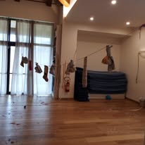 Sala allestita per un laboratorio Magicabula, con stoffe e amache sospese e materassini a terra
